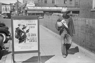 Migrant Worker Walking by U.S. Navy Recruitment Poster, Benton Harbor, Michigan, USA, John Vachon for Farm Security Administration July 1940