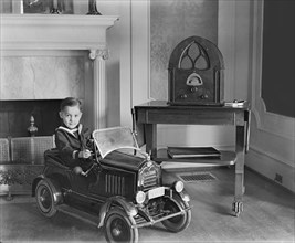 Young Boy Seated in Toy Automobile, USA, National Photo Company, 1920