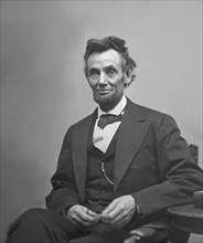 U.S. President Abraham Lincoln, Portrait, Seated next to Table Holding Spectacles and Pencil, Washington DC, USA, by Alexander Gardner, February 1865