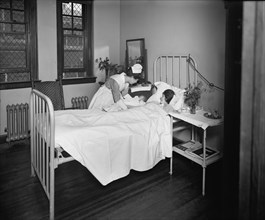 Nurse Bringing Newborn Infant to Mother in Hospital Room, Garfield Hospital, Washington, DC, USA, National Photo Company, 1921