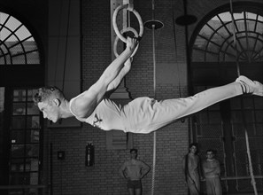 Gymnast on Still Rings, U.S. Naval Academy, Annapolis, Maryland, USA, by Lieutenant Whitman for Office of War Information, July 1942