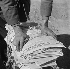Hands of Government Salvage Collector Wrapping Old Newspapers he had Gathered, Washington DC, USA, Gordon Parks for Office of War Information, November 1942