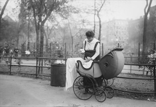 Woman with Baby Carriage Holding Milk Bottles from Depot set up by merchant Nathan Straus that Provides Pasteurized Milk to Poor Families, New York City, New York, USA, Bain News Service, 1917