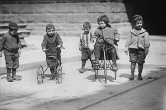 Group of Children Playing in Street, Two with Tricycles, New York City, New York, USA, Bain News Service, April 1909