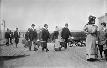 Immigrants Carrying Luggage, Ellis Island, New York City, New York, USA, Bain News Service, 1910