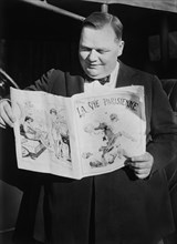 American Actor, Roscoe "Fatty" Arbuckle, Portrait Reading French Newspaper, La Vie Parisienne, Bain New Service, 1921
