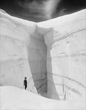 Man Standing next to Ice Grotto, Asulkan Glacier, Selkirk Mountains, British Columbia, Canada, Detroit Publishing Company, 1902