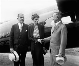 Amelia Earhart, Center, Portrait Shaking Hands with Man in front of Airplane, Harris & Ewing, 1932