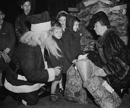 First Lady Eleanor Roosevelt Assisting in Distribution of Christmas Presents to Needy Children, Capitol Theater, Washington DC, USA, Harris & Ewing, December 23, 1939