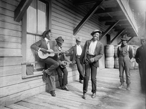 Group of Men Playing Music and Dancing on Porch, "Waiting for the Sunday Boat", William Henry Jackson for Detroit Publishing Company, 1902