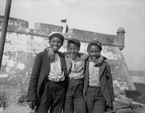 Portrait of Three Smiling Boys with Fort Matanzas in Background, "Happy as the Day is Long", St. Augustine, Florida, USA, William Henry Jackson for Detroit Publishing Company, 1902