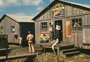 Group of Migratory Workers in front of Living Quarters and Juke Joint, Belle Glade, Florida, USA, Marion Post Wolcott for Farm Security Administration, February 1941