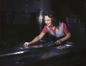 Female Worker Placing Metal Parts on Masonite Before Being Slid Under Multi-Ton Hydropress, North American Aviation, Inc., Inglewood, California, USA, Alfred T. Palmer for Office of War Information, O...