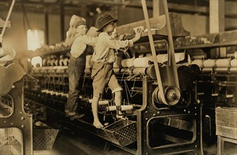 Two Young Boys Climbing on Spinning Frame to Mend Broken Threads and Put Back Empty Bobbins, Bibb Mill No. 1, Macon, Georgia, USA, Lewis Hine for National Child Labor Committee, January 1909
