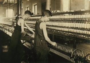 Tube Boy (left), 14 years old, Doffer Boy (right), 16 years old, Mule Spinning Room at Textile Mill, Fall River, Massachusetts, USA, Lewis Hine for National Child Labor Committee, June 1916