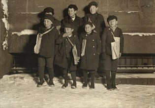 Group of Young Newsies Selling Newspapers at Night, Portrait Standing on Sidewalk in Snow, Hartford, Connecticut, USA, Lewis Hine for National Child Labor Committee, March 1909