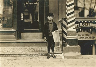 Tommy De Jucco, 9 years, Newsie, Portrait Standing on Sidewalk, Hartford, Connecticut, USA, Lewis Hine for National Child Labor Committee, March 1909
