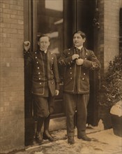 Two Bell Boys, Portrait Standing in Doorway During Break, Working until Midnight, Utica, New York, USA, Lewis Hine for National Child Labor Committee, February 1910