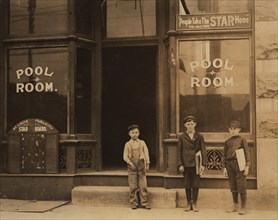 Three Young Newsboys, Portrait Standing outside Pool Hall after Receiving Afternoon Newspapers, Boys were Smoking and Playing Pool while Waiting for Papers, Youngest Boy is 9 years old and Sells until...