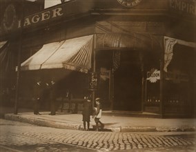 Two Young Boys Selling Newspapers on Street Corner outside Saloon, St. Louis, Missouri, USA, Lewis Hine for National Child Labor Committee, May 1910