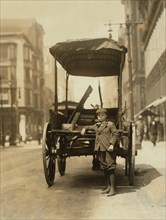 Young Boy Working as Assistant on Express Wagon, Adams Express Company, Portrait Standing with Wagon, St. Louis, Missouri, USA, Lewis Hine for National Child Labor Committee, May 1910