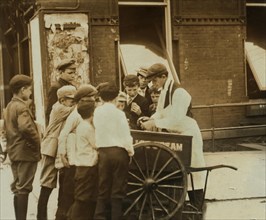 Group of Young Newsboys buying Ice Cream from Street Vendor, Wilmington, Delaware, USA, Lewis Hine for National Child Labor Committee, May 1910