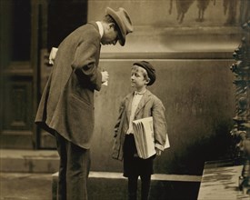 Michael McNelis, 8-year-old Newsboy, just recovering from Pneumonia, found Selling Papers in Rain Storm at time of photo, Portrait with Adult Man, Philadelphia, Pennsylvania, USA, Lewis Hine for Natio...