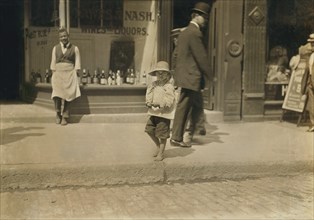 Willie Hutchinson, 6-yearl-old Newsie, Full-Length Portrait on Sidewalk, Richmond, Virginia, USA, Lewis Hine for National Child Labor Committee, June 1911