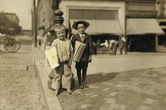 Willie (left), 6 years and Richard Green, 5 years, Young Newsboys, Full-Length Portrait on Sidewalk Selling Newspapers, Richmond, Virginia, USA, Lewis Hine for National Child Labor Committee, June 191...