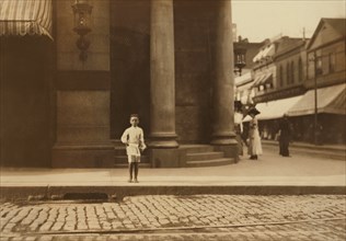 Young Newsboy, Full-Length Portrait Standing in Bare Feet on Sidewalk, New Bedford, Massachusetts, USA, Lewis Hine for National Child Labor Committee, August 1911