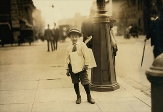 6-year old Newsie, Portrait Carrying Newspapers, Washington DC, USA, Lewis Hine for National Child Labor Committee, April 1912