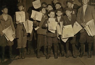 Group of Young Newsies, Full-Length Portrait Selling Newspapers on 12th Street after Midnight, Washington DC, USA, Lewis Hine for National Child Labor Committee, April 1912