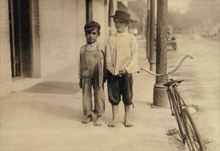 Two Young Newsboys, one is 6 years old, They begin their day at 6:00 a.m., Full-Length Portrait, San Antonio, Texas, USA, Lewis Hine for National Child Labor Committee, October, 1913
