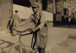 J.T. Marshall, 11 years old, Western Union Telegraph Messenger, Portrait Seated on Bicycle, Houston, Texas, USA, Lewis Hine for National Child Labor Committee, October 1913