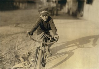 Curtis Hines, 14 years old, Western Union Messenger, Works 4:00-8:00 p.m., Full-Length Portrait Sitting on Bicycle, Houston, Texas, USA, Lewis Hine for National Child Labor Committee, October 1913