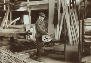 Boy Tying Up Wood Boards at Planing Mill, Evansville, Indiana, USA, Lewis Hine for National Child Labor Committee, October 1908