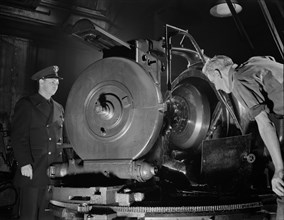 Worker Inspecting Gears of Rear Axles of Army's Half-Track Scout Car at Factory Converted to War Production, White Motor Company, Cleveland, Ohio, USA, Alfred T. Palmer for Office of War Information, ...