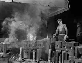 Operator of Electric Furnace Pouring Molten Metal into Molds, Chase Brass and Copper Company, Euclid, Ohio, USA, Alfred T. Palmer for office of War Information, February 1942