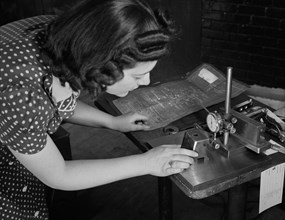Estelle Wilson, one of a Razor Factory's Many Women Workers, Checking Completed V-blocks with Blueprint Specification, as this factory was Sub-Contracted for Production of War Tools, Boston, Massachus...