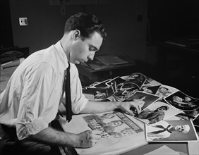 Office of War Information Artist Selecting Photographs to Create Rough Layout for Poster of "Men Working Together", Washington DC, USA, November 1941