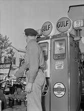 Gas Station Attendant Pumping Gas while Keeping an eye on Gauge during Gasoline Rationing, USA, Office of War Information, 1940's