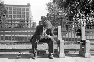 Man Smoking Cigarette on Park Bench, Gateway District, Minneapolis, Minnesota, USA, John Vachon for U.S. Resettlement Administration, September 1939