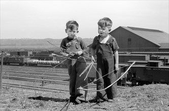 Two Young Boys Playing with Bows and Arrows near Railroad Yards, Dubuque, Iowa, USA, John Vachon for Farm Security Administration, April 1940
