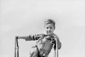 Portrait of Young Boy at Top of Playground Slide, Child of Migratory Worker, Weslaco, Texas, USA, Arthur Rothstein for Farm Security Administration, January 1942