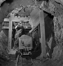 Worker Loading Mercury Ore from Chute into Mine Car, Quicksilver Mining Company, New Idria, California, USA, Andreas Feininger for Office of War Information, December 1942