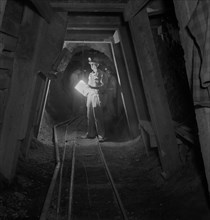 Worker Inspecting New Timbering in Mining Tunnel, Quicksilver Mining Company, New Idria, California, USA, Andreas Feininger for Office of War Information, December 1942