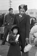Japanese-American Mother and Daughter Waiting for Train to Owens Valley During Evacuation of Japanese-Americans from West Coast Areas under U.S. Army War Emergency Order, Los Angeles, California, USA,...