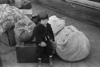 Japanese-American Child Waiting for Train to Owens Valley During Evacuation of Japanese-Americans from West Coast Areas under U.S. Army War Emergency Order, Los Angeles, California, USA, Russell Lee, ...