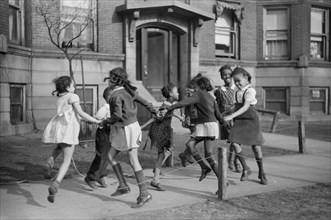 Group of Girls Playing Ring-Around-a-Rosie on Sidewalk in "Black Belt" Neighborhood, Chicago, Illinois, USA, Edwin Rosskam for Office of War Information, April 1941