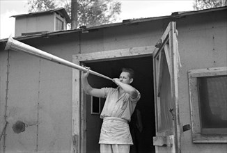 Cook at Lumber Camp Blowing Dinner Horn, near Effie, Minnesota, USA, Russell Lee, U.S. Resettlement Administration, September 1937